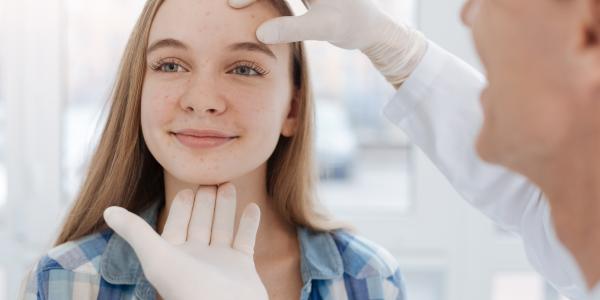 dermatologist inspecting teens face